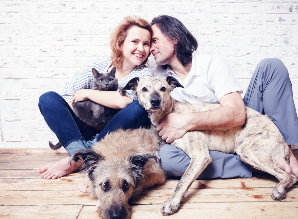 couple with two dogs and a cat
